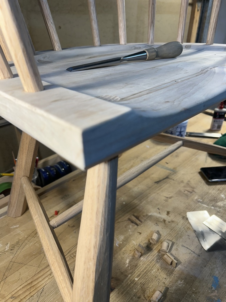 Carved seat with a chisel resting on it